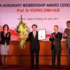 Bô trưởng Vương Đình Huệ đón nhận danh hiệu viên danh dự ACCA. (Ảnh: Phạm Hậu/TTXVN)
