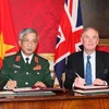 Thứ trưởng Nguyễn Chí Vinh và Thứ trưởng, Huân tước Astor ký Bản ghi nhớ hợp tác quốc phòng Việt-Anh. (Ảnh: Vũ Hội-Lê Dương/Vietnam+)