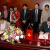 Thứ trưởng Bộ Nông nghiệp và Phát triển Nông thôn Bùi Bá Bổng và bà Rosenholm, Phó Đại sứ Đan Mạnh tại Việt Nam ký thỏa thuận. (Ảnh: Đình Huệ/TTXVN)
