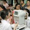 Cán bộ y tế khám mắt cho trẻ em nghèo tại Hà Nội. (Ảnh: Dương Ngọc/TTXVN)