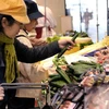 Khách hàng chọn mua rau quả trồng ở các tỉnh gần nhà máy điện hạt nhân Fukushima tại siêu thị Daimaru, ngày 6/4/2011. (Nguồn: AFP/TTXVN)