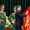 Thường trực Ban Bí thư Lê Hồng Anh gắn danh hiệu Anh hùng lực lượng vũ trang nhân dân lên lá cờ truyền thống của Văn phòng TW Cục miền Nam. (Ảnh: Thế Anh/TTXVN)
