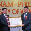 Bộ trưởng Bộ Giao thông vận tải Đinh La Thăng trao Huân chương Hữu nghị cho ông Johnathan Hạnh Nguyễn. (Ảnh: Hoàng Anh Tuấn/Vietnam+)