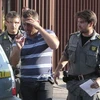 Cảnh sát áp giải một trong những kẻ bị bắt giữ trong một tổ chức mafia. (Nguồn: AFP/TTXVN)