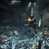 Lính cứu hỏa làm việc tại tòa nhà trong khuôn viên trường học của Mỹ bị đốt cháy trong biểu tình bạo động ở thủ đô Tunis, Tunisia ngày 14/9. (Nguồn: AFP/TTXVN)