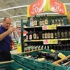 Nhân viên dỡ các chai rượu khỏi giá tại siêu thị ở Brno ngày 14/9. (Nguồn: AFP/TTXVN)