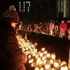 Thắp nến tưởng niệm các nạn nhân động đất tại buổi lễ ở Kobe. (Nguồn: AFP/TTXVN)