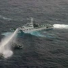 Tàu của lực lượng phòng vệ bờ biển Nhật Bản (phải) phun vòi rồng chặn tàu của Đài Loan (trên, trái) ở gần quần đảo tranh chấp ngày 24/1. AFP/ TTXVN