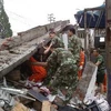 Tìm cứu nạn nhân bị mắc kẹt trong đống đổ nát sau động đất ở huyện Lô Sơn, tỉnh Tứ Xuyên ngày 21/4. (Nguồn: THX/TTXVN)