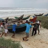 Ngư dân Quảng Trị vận chuyển ngư lưới cụ lên bờ phòng chống bão số 11. (Ảnh: Hồ Cầu/TTXVN)