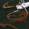 Tàu cứu hộ đang cố làm sạch các vệt dầu trên mặt biển. (Nguồn: The Huffington Post)