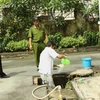 Cảnh sát môi trường lấy mẫu nước thải xét nghiệm. (Nguồn: Internet)