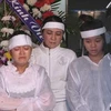 Đối tượng Trần Thúy Liễu cùng hai con trong lễ tang nhà báo Hoàng Hùng. (Nguồn: Internet)