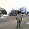 Một chiếc xe buýt bị đốt cháy trong cuộc xung đột. (Nguồn: THX/TTXVN)