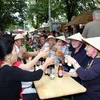 Khách quốc tế thưởng thức bia tại gian hàng Việt Nam. (Ảnh: Văn Long-Thanh Hải/Vietnam+)
