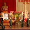 Phó Chủ tịch nước Nguyễn Thị Doan tặng bức hình chân dung Chủ tịch Hồ Chí Minh cho LLVT Quân khu 9. (Ảnh: Thanh Sang/Vietnam+)