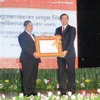 Thống đốc ngân hàng Quốc gia Campuchia Chea Chanto (trái) trao quyết định cho đại diện Sacombank Việt Nam. (Ảnh: Tuấn Anh/Vietnam+)
