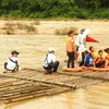 Các em học sinh qua sông Tang bằng bè tre. (Nguồn: vnexpress.net)