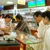 Người tiêu dùng mua sắm hàng hóa tại siêu thị Nguyễn Kim. (Ảnh: Kim Phương/TTXVN)
