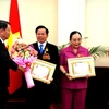 Ông Lê Văn Kiểm và bà Trần Cẩm Nhung nhận Huân chương Hữu nghị của Chính phủ Lào. (Ảnh: Hoàng Chương/Vietnam+)