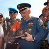 Các quan chức Nga và Indonesia cầm một phần hộp đen bị hỏng của SSJ-100 tại căn cứ tìm kiếm cứu hộ ở Cijeruk, gần núi Salak. (Nguồn: AFP)
