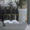 Các nhân viên an ninh đứng gần thi thể các cảnh sát liên bang bị sát hại tại sân bay quốc tế của thủ đô Mexico City. (Nguồn: AP)