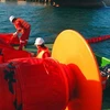 Các cơ quan chức năng dùng phao vây ngăn chặn sự cố tràn dầu ở cảng Dung Quất. (Nguồn: tinngan.vn)