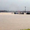 Nhiều nhà dân bị ngập lụt và chia cắt vì bão lũ. (Nguồn: TTXVN)
