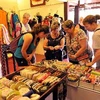 Du khách nước ngoài mua sắm đồ lưu niệm tại Huế (Ảnh: Thanh Hà/TTXVN)