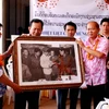 Đoàn cựu phóng viên TTXVN trao tặng Thông tấn xã KPL bức ảnh quý về đồng nghiệp trong chiến tranh (Ảnh: Hoàng Chương/Vietnam+)