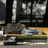 Một người đàn ông vô gia cư ngủ trên ghế tại quảng trường trung tâm Syntagma, Athens. (Nguồn: AP).