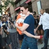 Tom Cruise bế con gái ra khỏi khách sạn ở New York ngày 17/7. (Nguồn: Reuters).