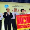 Phó Thủ tướng Nguyễn Xuân Phúc trao cờ thi đua Chính phủ cho trường Đại học Luật Thành phố Hồ Chí Minh. (Ảnh: Hoàng Hải/Vietnam+)