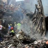 Lực lượng cứu trợ làm việc tại hiện trường vụ tai nạn máy bay ngày 4/6 tại Nigeria. (Ảnh: AFP/TTXVN)