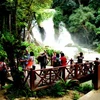 Khách du lịch thăm thác Kuang si – LuongPhabang. (Ảnh: Hoàng Chương/Vietnam+) 