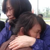 Một người phụ nữ trong Đoàn bảo tàng hoà bình - Hàn Quốc (áo tím) cùng chị Đặng Thị Khoá (nhân chứng sống sót) ôm nhau khóc tại lễ tưởng niệm. (Ảnh: Nguyễn Sơn/Vietnam+) 