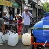 Người dân phải đi mua nước sạch về dùng. (Ảnh minh họa: Hoàng Hải/TTXVN) 
