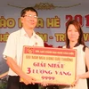 Nữ công nhân Huỳnh Ái Lệ nhận 3 lượng vàng 9999 từ Ban giám đốc khu du lịch Đại Nam. (Ảnh: Dương Chí Tưởng/Vietnam+)