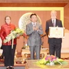 Thứ trưởng Trần Hồng Hà trao Kỷ niệm chương cho Tiến sĩ Michael Parsons (bên phải). (Nguồn: monre.gov.vn)