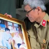 Nhà văn, nhà báo Nguyễn Thế Tường với bức ảnh quý ghi lại khoảnh khắc đáng nhớ bên Đại tướng. (Ảnh: Võ Thành/Vietnam+)