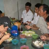 Phụ huynh và thí sinh tranh thủ ăn trưa tại khu vực Trường đại học Bách Khoa. (Ảnh/Vietnam+)
