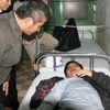 Chủ tịch Tổng Liên đoàn lao động Việt Nam Đặng Ngọc Tùng đến thăm phóng viên Trần Thế Dũng khi anh đang điều trị tại Bệnh viện Việt – Đức. (Ảnh: NLĐ)