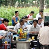 Một quán trà đá trước cổng Đại học Thủy lợi thu hút rất nhiều phụ huynh ngồi uống nước. (Ảnh: Kỳ Dương/Vietnam+)