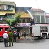 Cảnh sát phòng cháy chữa cháy đang tiến hành dập tắt vụ cháy. (Ảnh: Mạnh Hùng/Vietnam+)