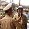Cảnh sát giao thông đang yêu cầu người điều khiển phương tiện kiểm tra nồng độ cồn. (Ảnh: Việt Hùng/Vietnam+)