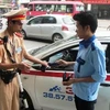 Cảnh sát giao thông tiến hành xử phạt lái xe taxi vi phạm. (Ảnh: Việt Hùng/Vietnam+)