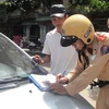 Lực lượng Cảnh sát giao thông tiến hành xử phạt xe taxi vi phạm. (Ảnh: Việt Hùng/Vietnam+)