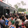 Hành khách từ các tỉnh đổ xô về Hà Nội chen chân bắt xe buýt để về nhà. (Ảnh: Hùng Dũng/Vietnam+)