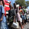 Người dân Haiti chờ nhận nước sạch sau động đất tại thủ đô Port au Prince ngày 14/1. (Ảnh: AFP/TTXVN)
