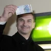 Thủ tướng Estonia Andrus Ansip cầm những đồng Euro đầu tiên từ một máy rút tiền tự động. (Nguồn: Reuters)